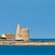 A castle and a building on a coastline